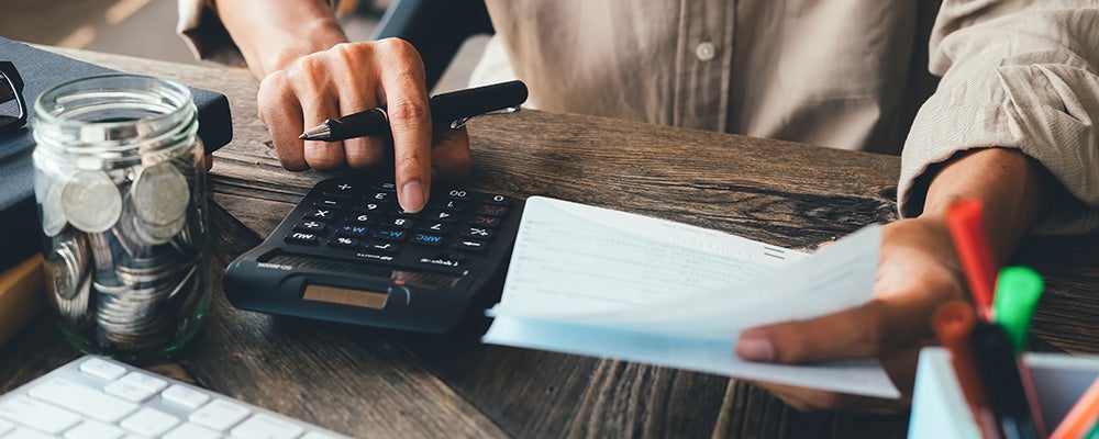 Someone using a calculator to determine if they can buy a used car